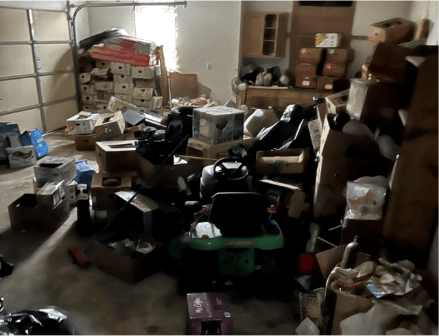 Heaps of boxes and junk taking up space in a Delaware garage, blocking the lawnmower