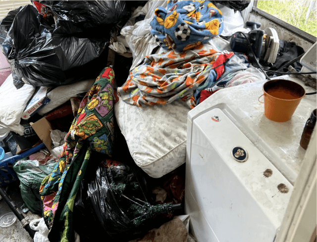 Piles of junk awaiting removal in a laundry room after a tenant left a rental property